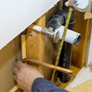 Plumber repairing pipes in wall